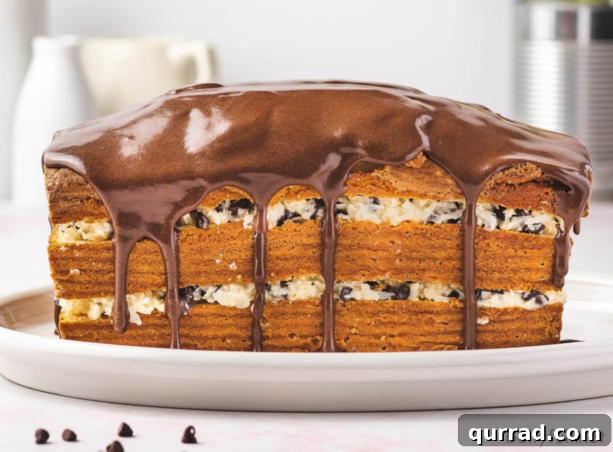 Divine Coconut Chocolate Layered Pound Cake 3 Front view of an assembled Coconut-Chocolate Layered Pound Cake with a glossy chocolate ganache cascading down the sides
