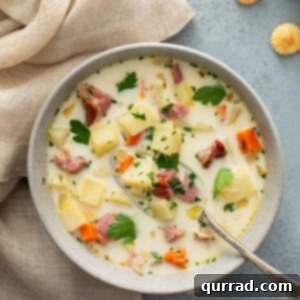 overhead of ham and potato soup in bowl with spoon and napkin