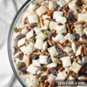 15-minute Chex Mix Muddy Buddies with a Christmas holiday flair, including white chocolate, powdered sugar, pretzels, craisins, and pistachios!