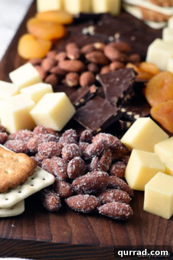 Craft a simple, beautiful cheese and nut board in just 15 minutes! A vibrant cheese and nut board featuring almonds, various cheeses, dark chocolate, and dried apricots artfully arranged on a rustic serving board.