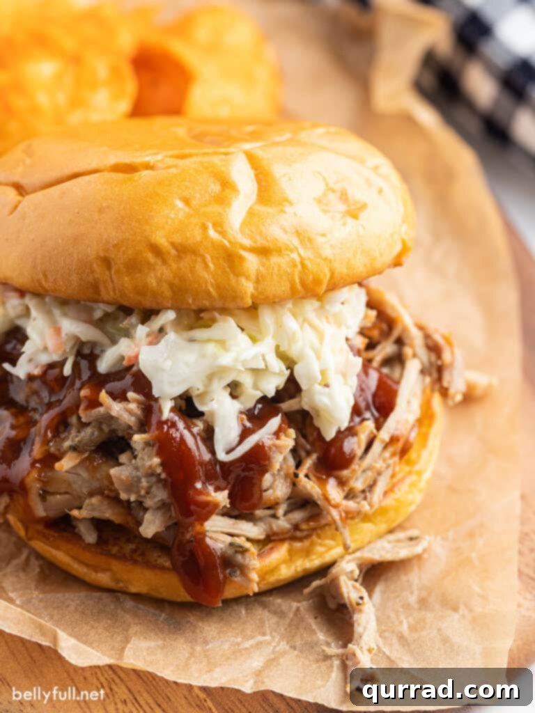 The Ultimate Pulled Pork 2 Pulled pork sandwich with coleslaw and BBQ sauce, showcasing a delicious and easy recipe.