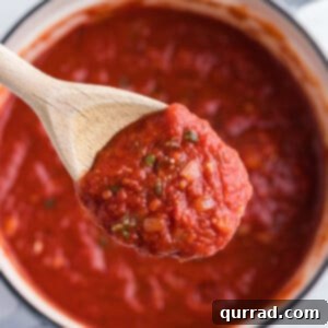overhead close up marinara sauce on wooden spoon