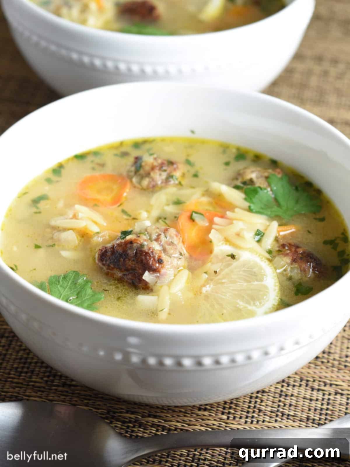 Hearty Meatball Soup 3 meatball soup with orzo and lemon slice in white bowl