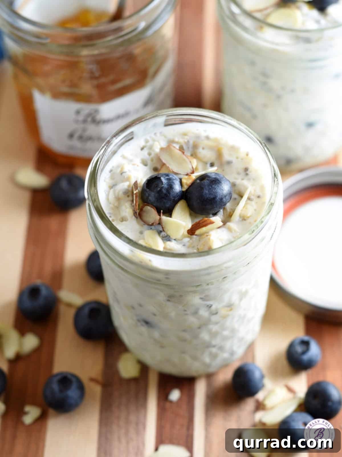 Close-up of overnight breakfast oats in a glass jar, layered with blueberries and topped with sliced almonds, ready to be enjoyed.