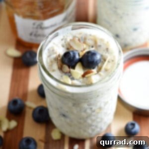 overnight breakfast oats in glass jar with blueberries and sliced almonds