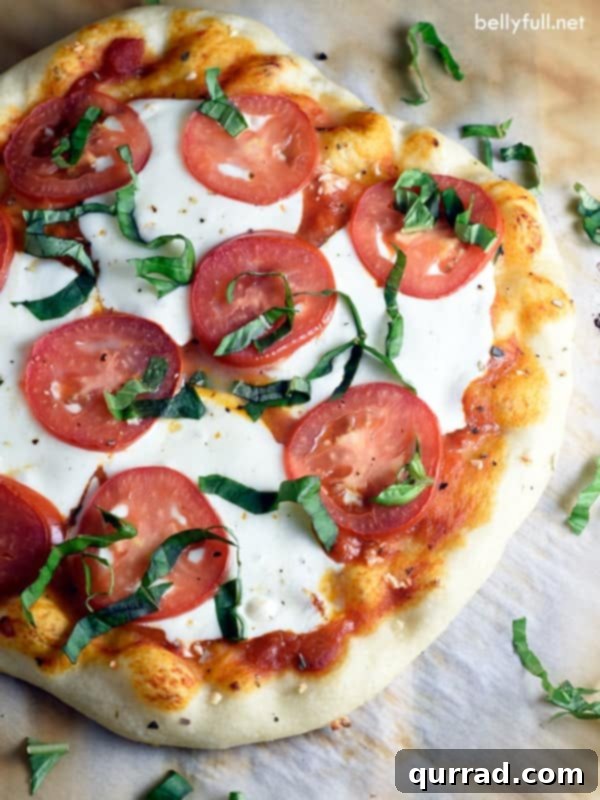 Made with fresh marinara sauce, mozzarella cheese, and basil, Classic Margherita pizza is simple, so easy, and absolutely delicious! overhead homemade margherita pizza on parchment paper