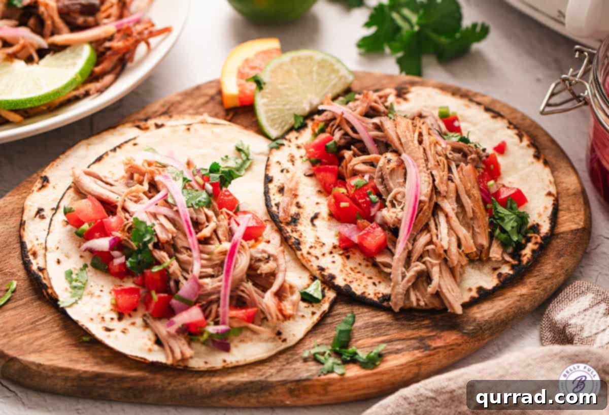 Shredded Cuban pork on tortillas with pico de gallo, close-up.