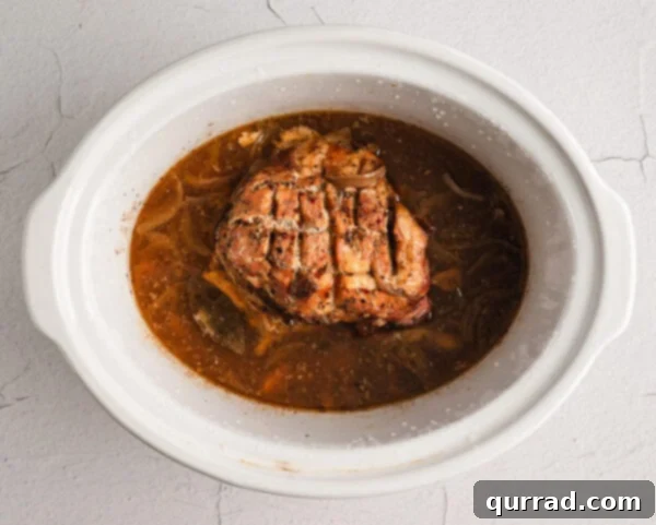 Cooked Cuban pork, still in the crockpot, showing its tenderness.
