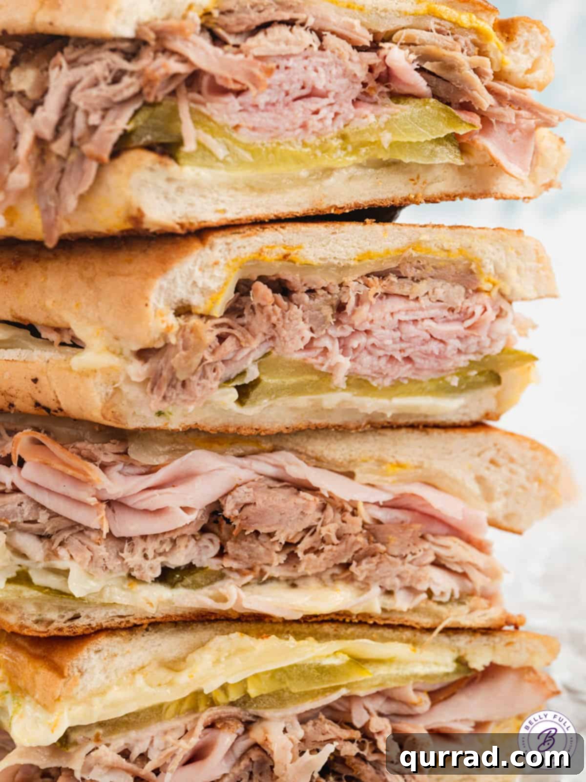 Havana's Golden Press 5 A stack of golden-brown, perfectly pressed Cuban sandwiches, sliced and ready for serving.
