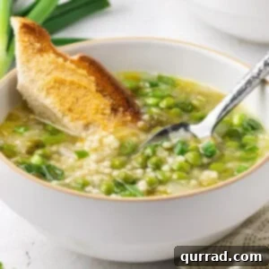 A bowl of Spring Onion and Pea Soup with toasted bread, ready to be enjoyed.