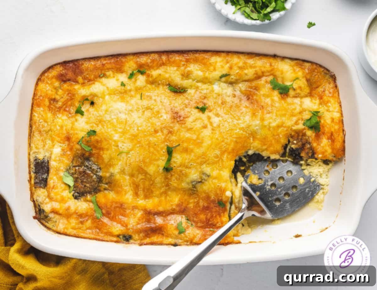 Close-up shot of a single portion of Chile Relleno Casserole on a plate, showing the distinct layers of peppers, cheese, and baked egg, with a serving spatula beside the casserole dish.