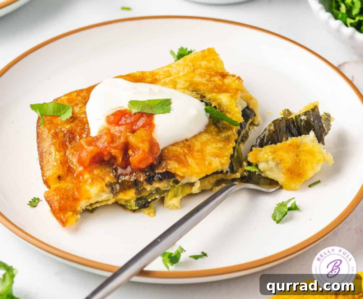 A close-up of a square portion of baked Chile Relleno Casserole on a white plate, showcasing the texture and golden-brown top, with a fork ready to dig in.