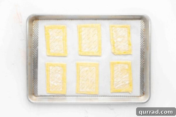 Springtime Asparagus Gems 6 Overhead view of 6 unbaked puff pastry rectangles on parchment paper, ready for filling.
