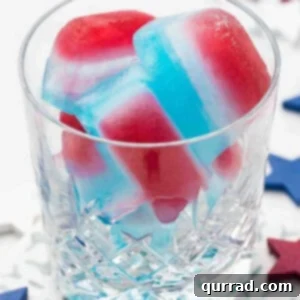Red, white, and blue layered ice cubes in a glass