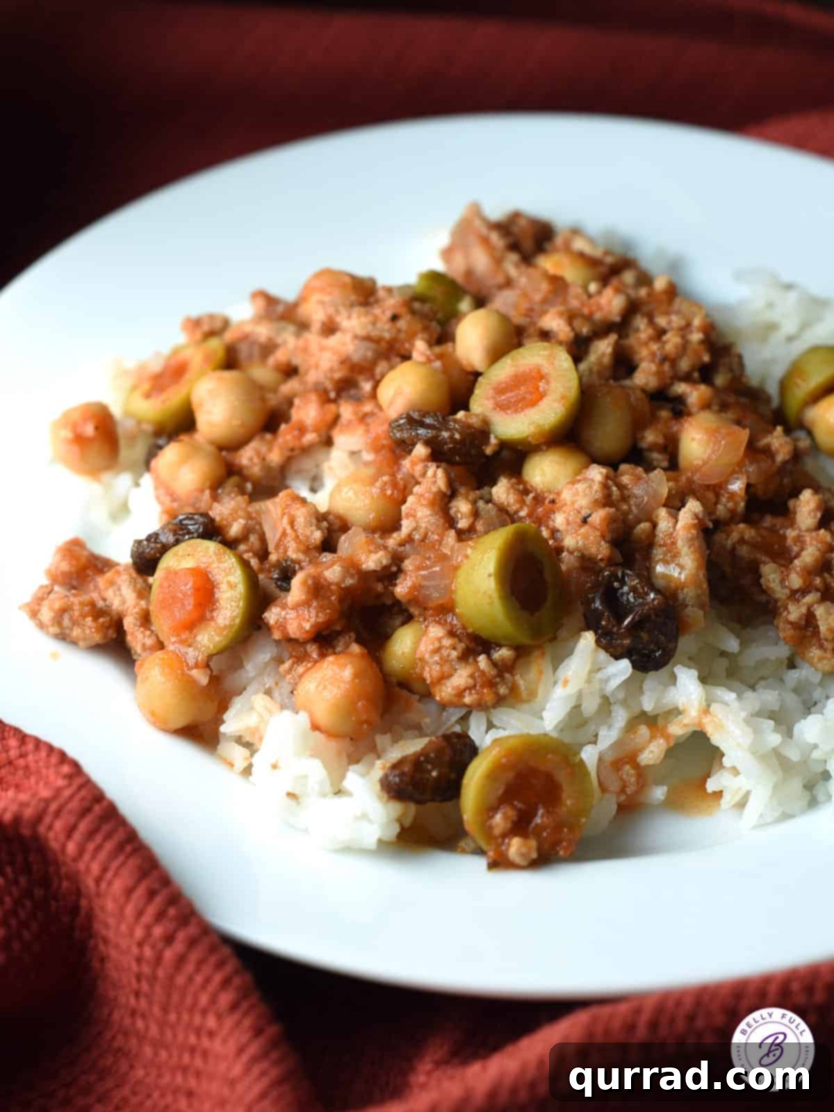 Ground turkey picadillo with tomatoes and olives served over rice in a bowl