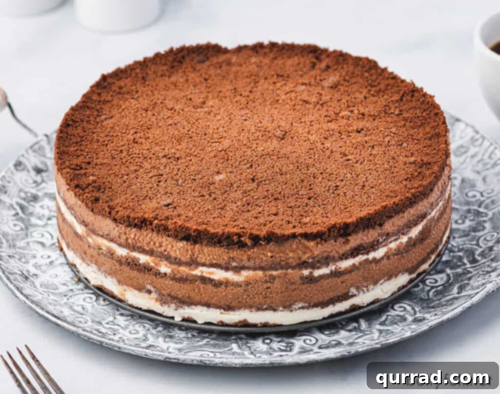 Decadent No-Bake Chocolate Delight 3 uncut chocolate layered cake on ornate plate
