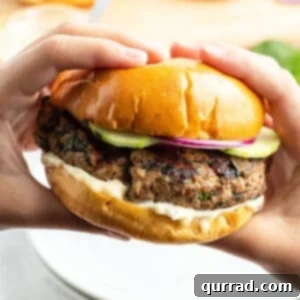 hands holding grilled turkey burger on bun