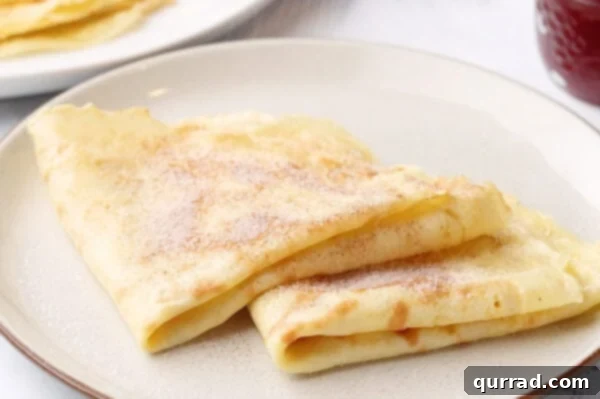 Folded crepes elegantly sprinkled with cinnamon-sugar, ready to be enjoyed.