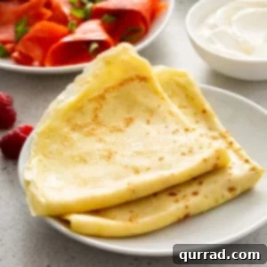 Stacked, perfectly golden crepes on a plate, ready for serving.