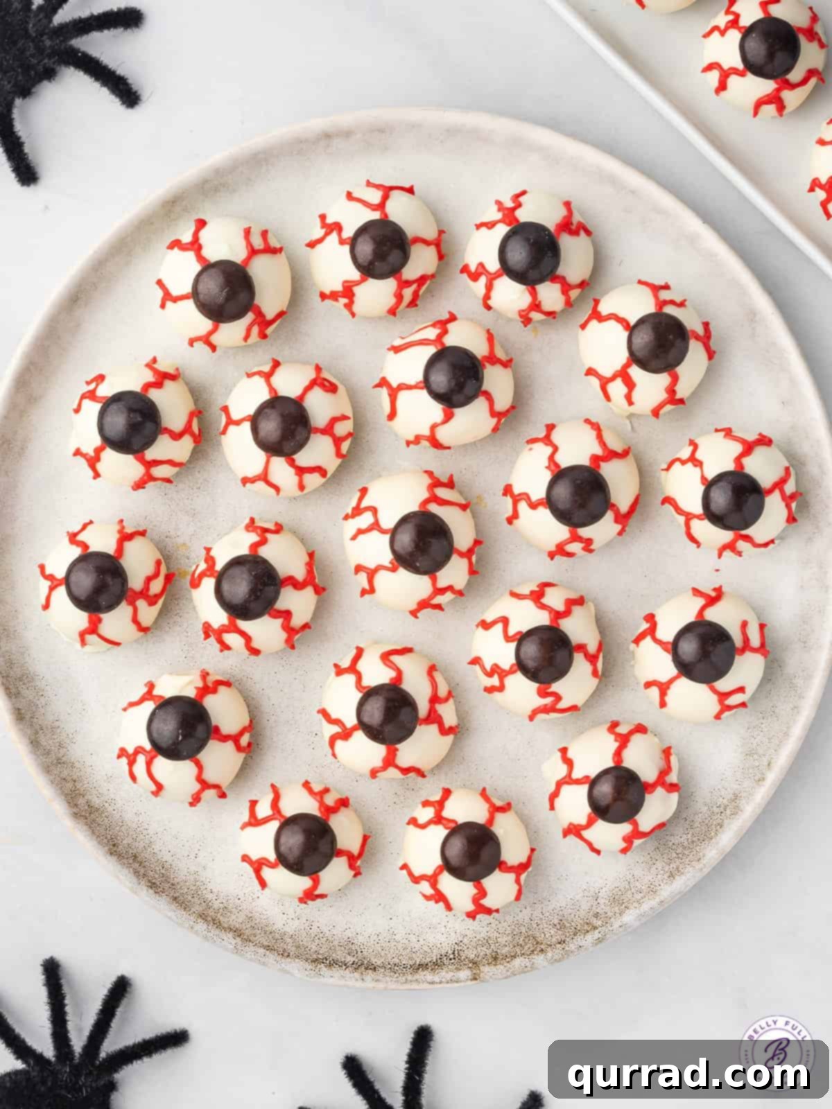 Overhead plate of chocolate-coated candy eyeballs for Halloween, ready for serving.