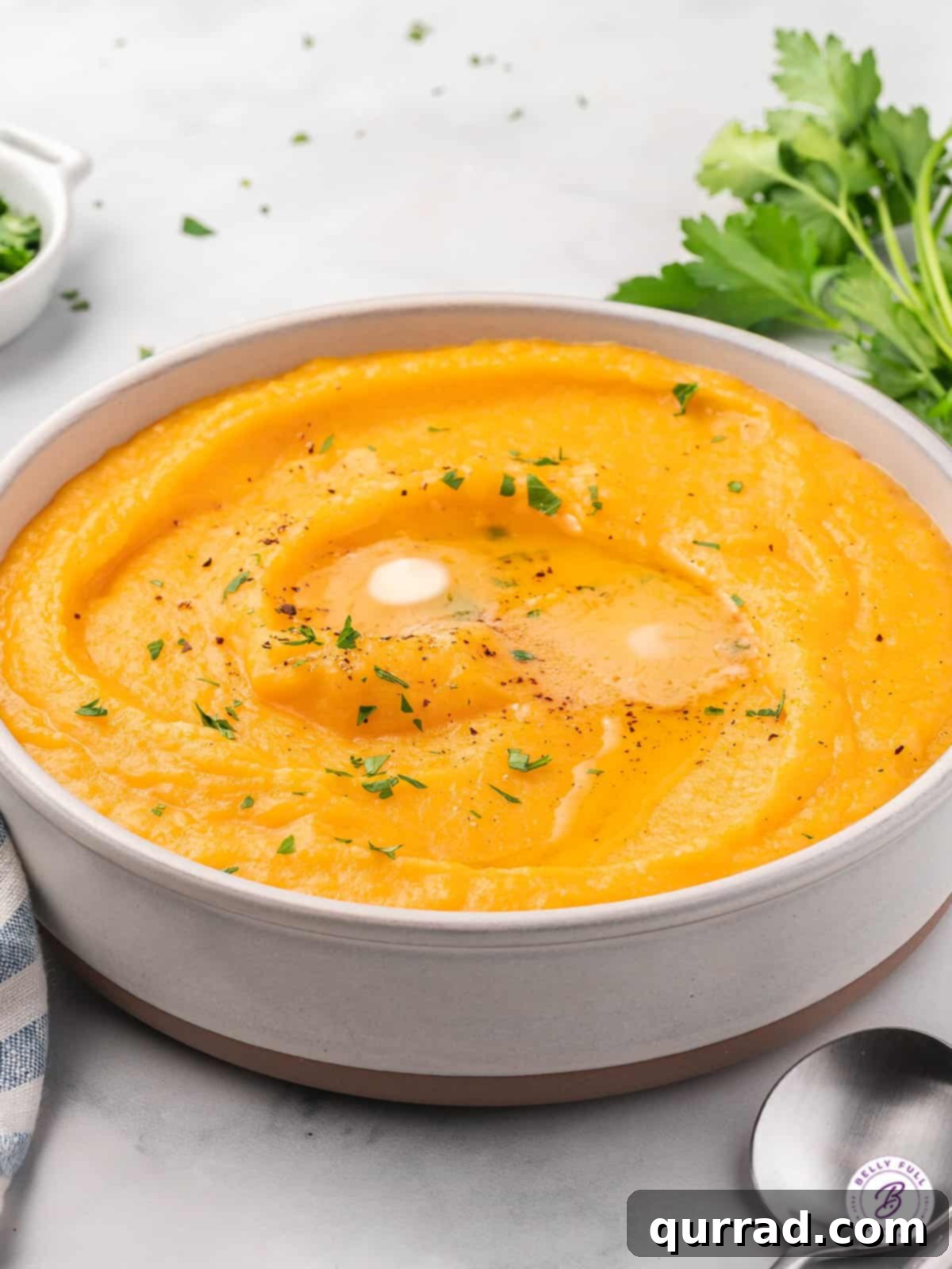 butternut squash mash in bowl with melted pat of butter