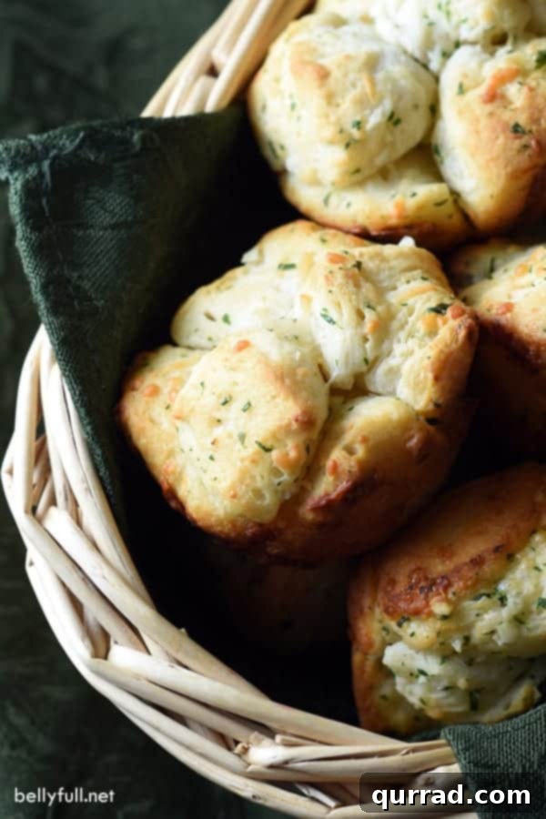 Savory Monkey Bread Muffins in a bread basket with a green napkin, perfect for dinner