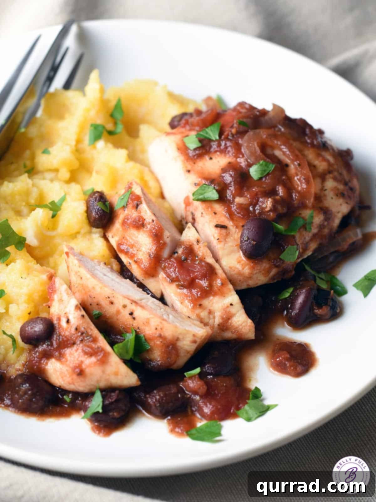 Tender Slow Cooker Balsamic Tomato Chicken 4 sliced chicken breast with black beans and tomato sauce on a serving plate
