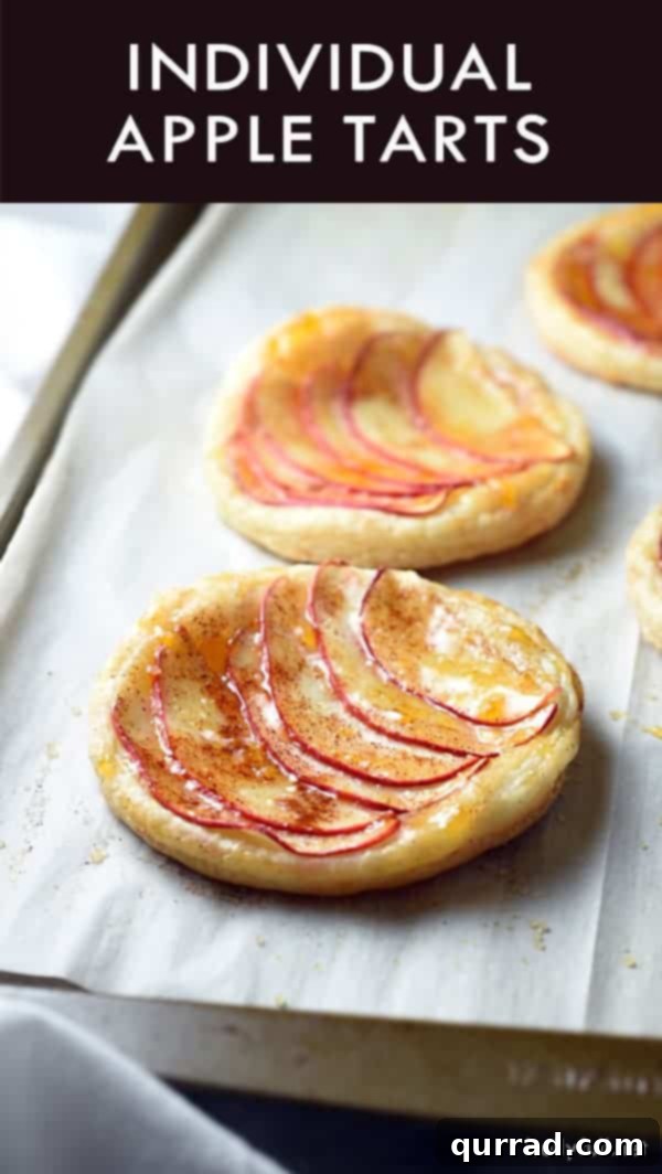 Close-up of Individual Apple Tarts showing the crispy edges of the puff pastry and neatly fanned apple slices.