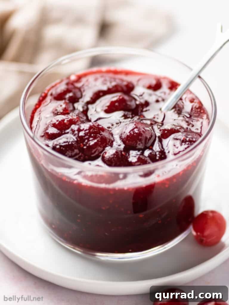 Sweet and Tart Homemade Cranberry Sauce 2 A close-up shot of homemade whole berry cranberry sauce in a small serving cup, showcasing its rich red color and plump berries.