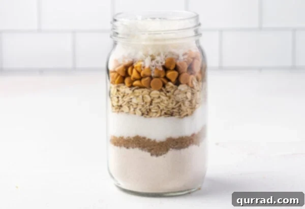 Layers of Cookie Joy 7 cookie mix ingredients layered in glass jar