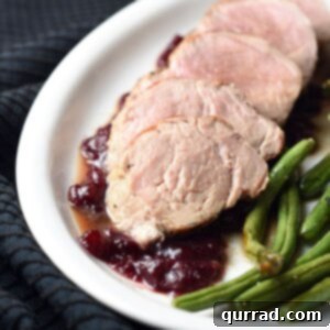 Pork Tenderloin with Roasted Garlic and Cracked Black Pepper 5 Close-up of roasted garlic and cracked black pepper pork tenderloin with festive cranberry-pomegranate sauce