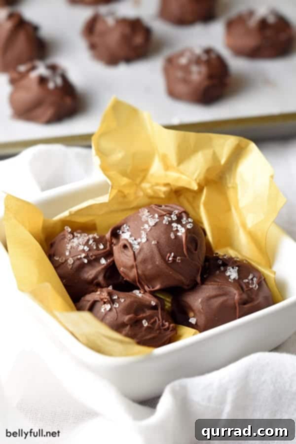 Decadent Chocolate Almond Truffles 2 Chocolate almond truffles wrapped in yellow tissue paper in white bowl