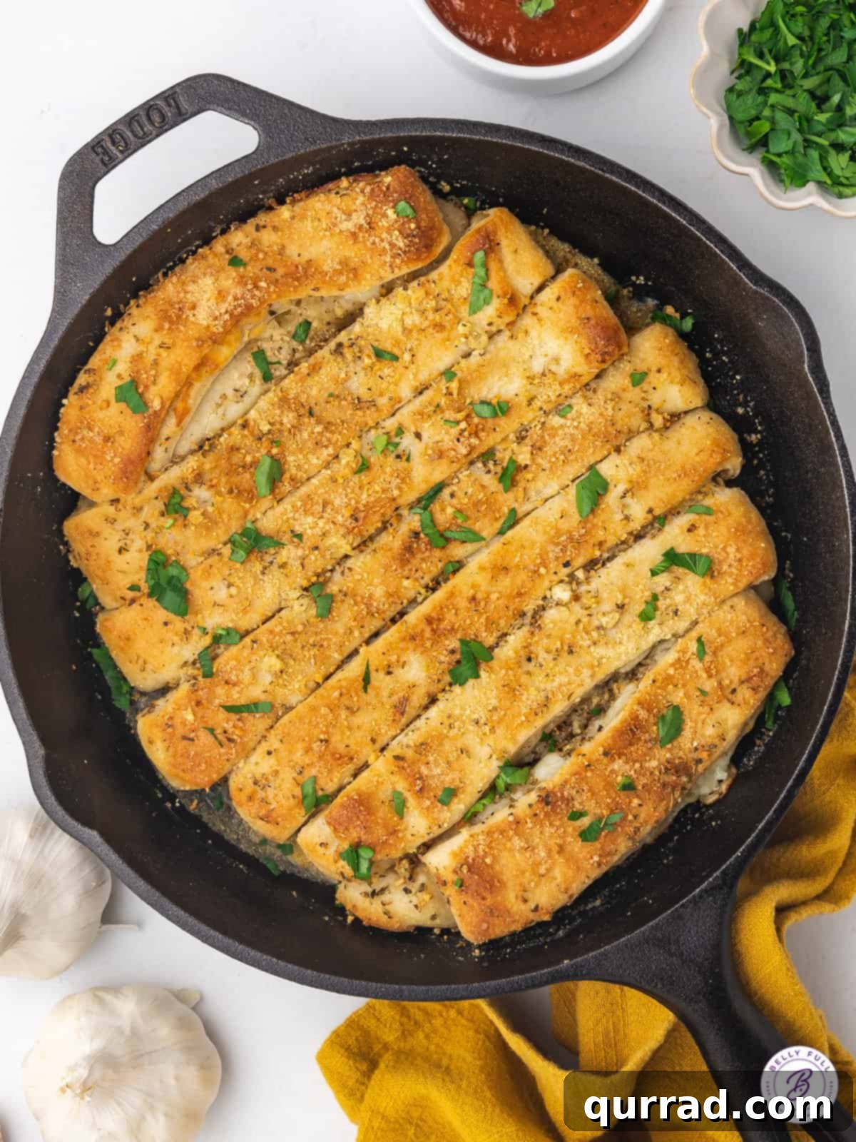 Effortless Skillet Breadsticks 3 Freshly baked cheesy breadsticks arranged artfully in a cast iron skillet, golden brown and ready to serve.