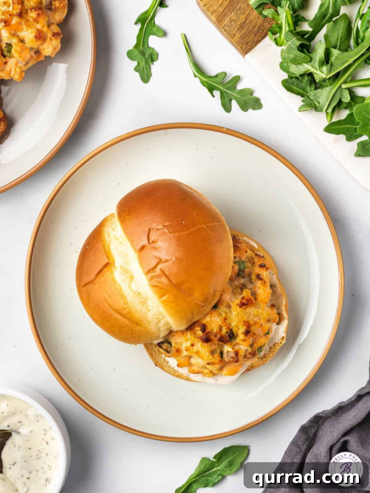 Gourmet Salmon Burgers 3 Overhead shot of a delicious salmon burger served on a brioche bun.