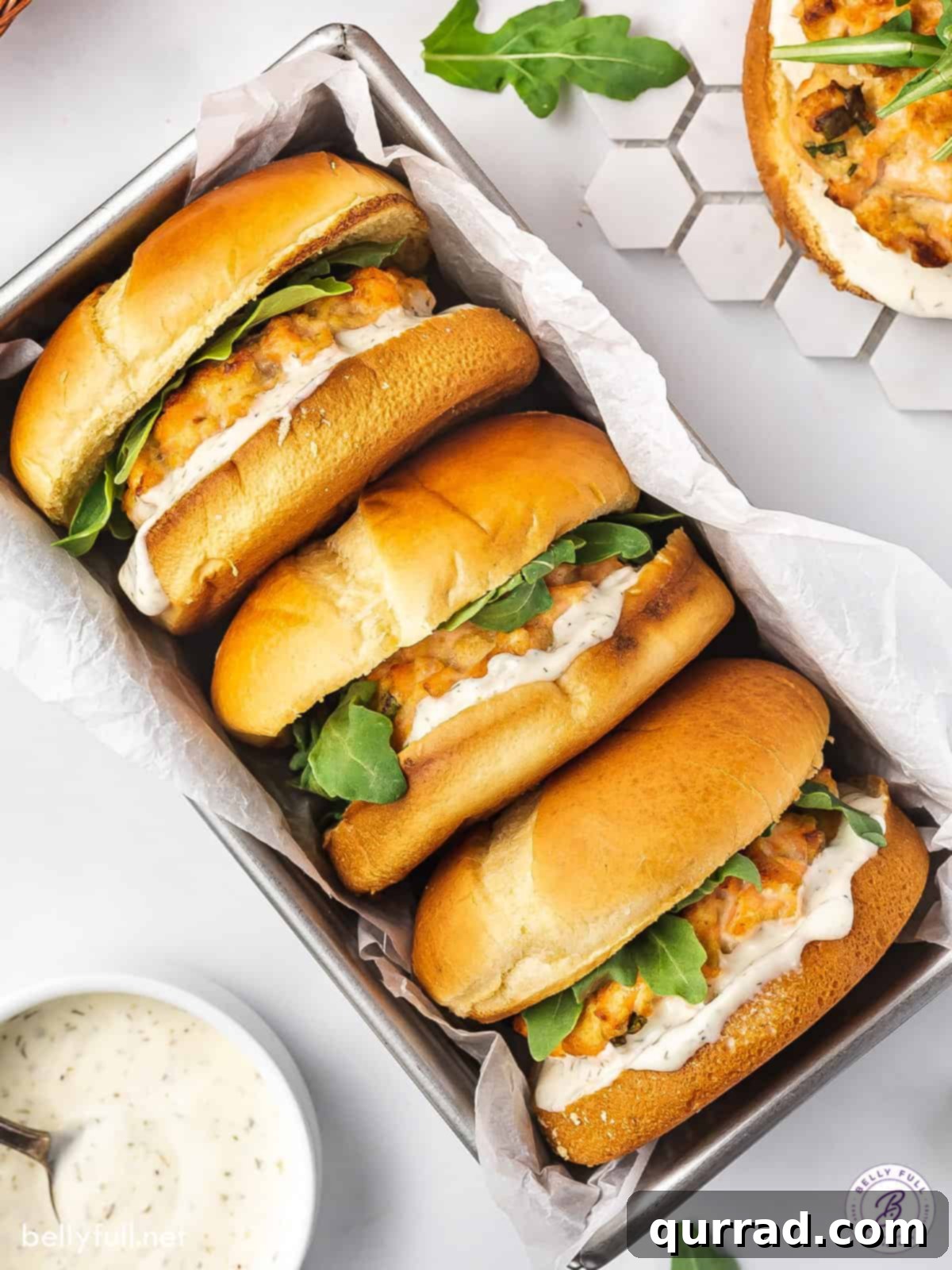 Gourmet Salmon Burgers 4 Overhead view of three salmon burgers in a basket with parchment paper, ready to be served.