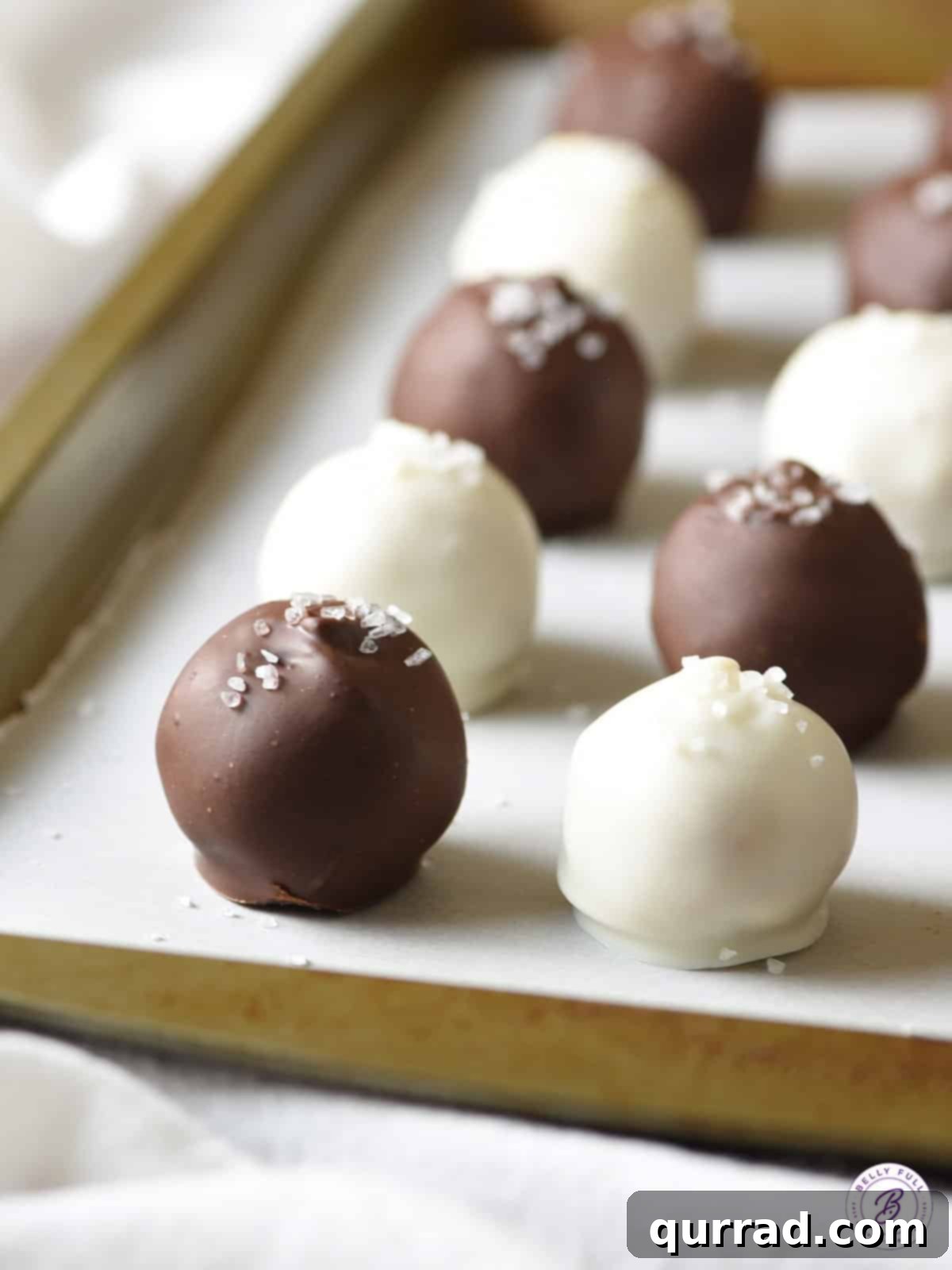 Holiday Eggnog Truffles 3 white and dark chocolate coated truffles on baking sheet