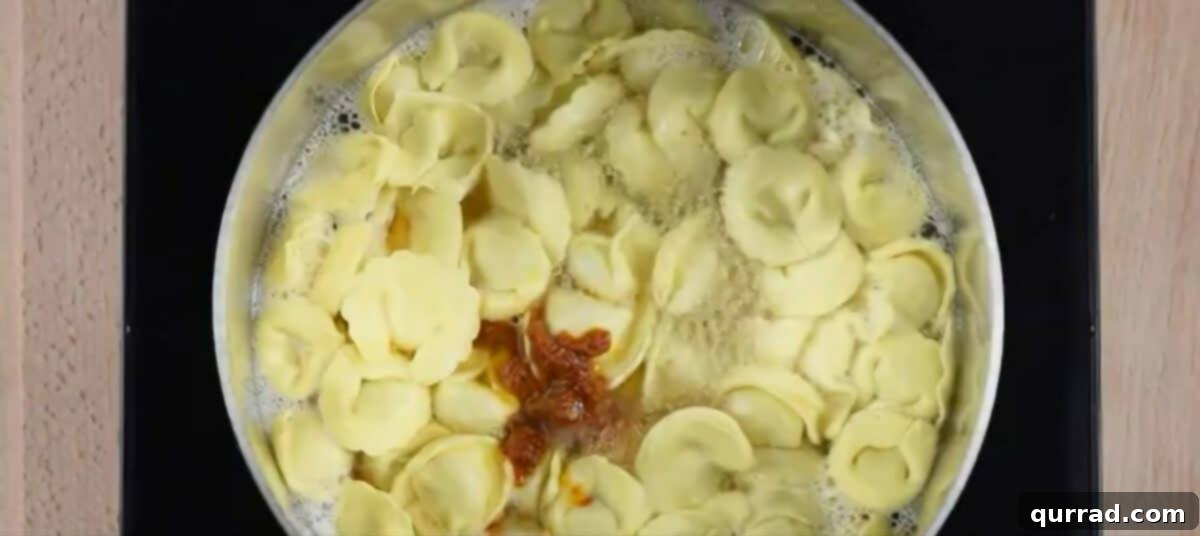 Adding sundried tomato pesto to the pot. 