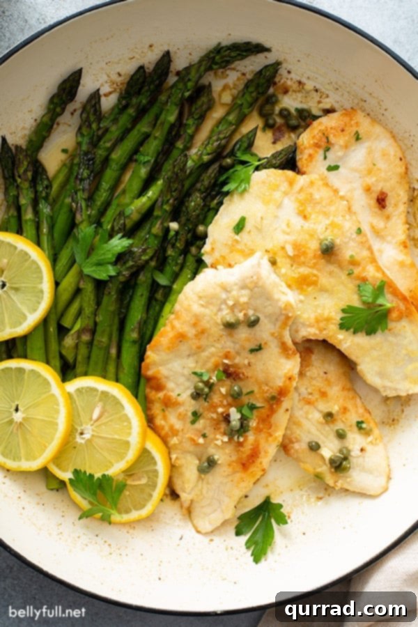 Chicken Piccata with Roasted Asparagus Side Overhead view of perfectly cooked, breaded chicken cutlets arranged on a serving plate alongside vibrant roasted asparagus.