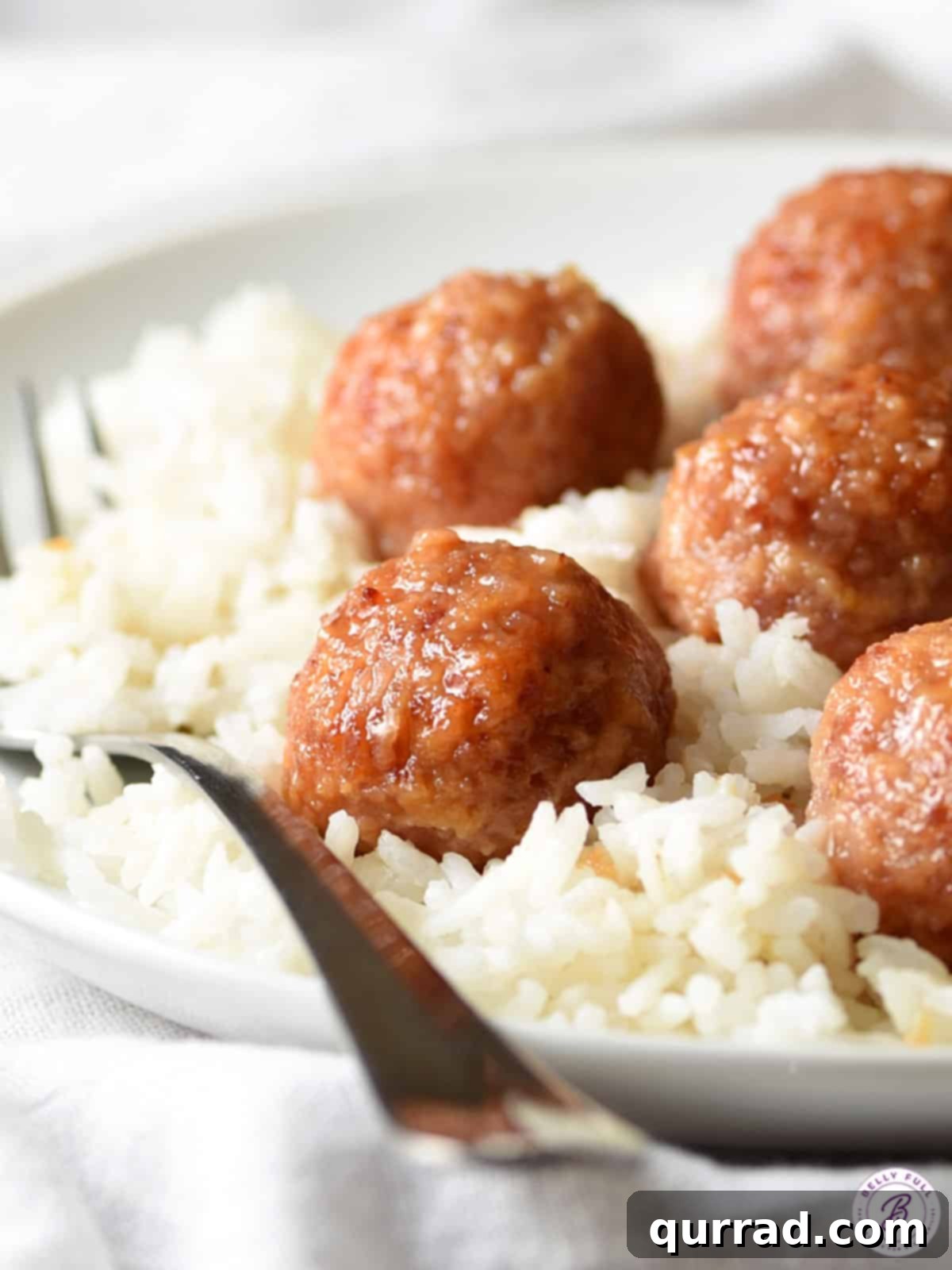 Savory Ham Bites 2 Close up view of glazed ham balls served over a bed of fluffy white rice, ready to be enjoyed.