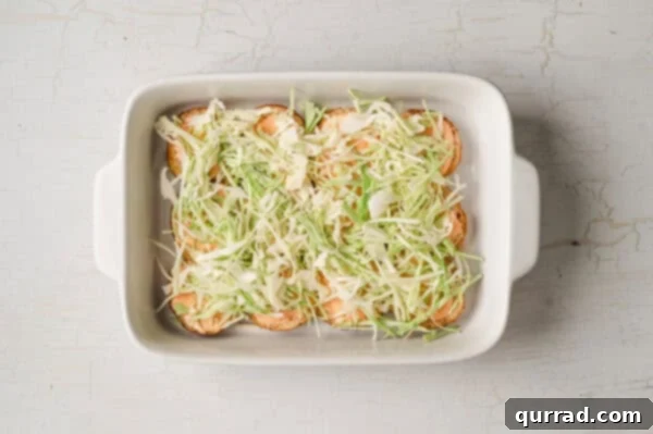 bottom buns in casserole dish with thousand island dressing and shredded cabbage