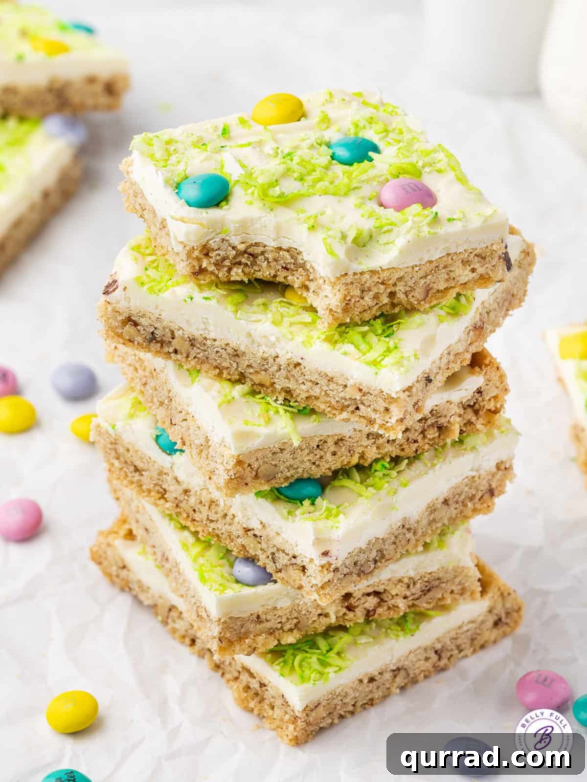 A stack of six frosted Easter Sugar Cookie Bars, decorated with pastel M&Ms, ready for serving.