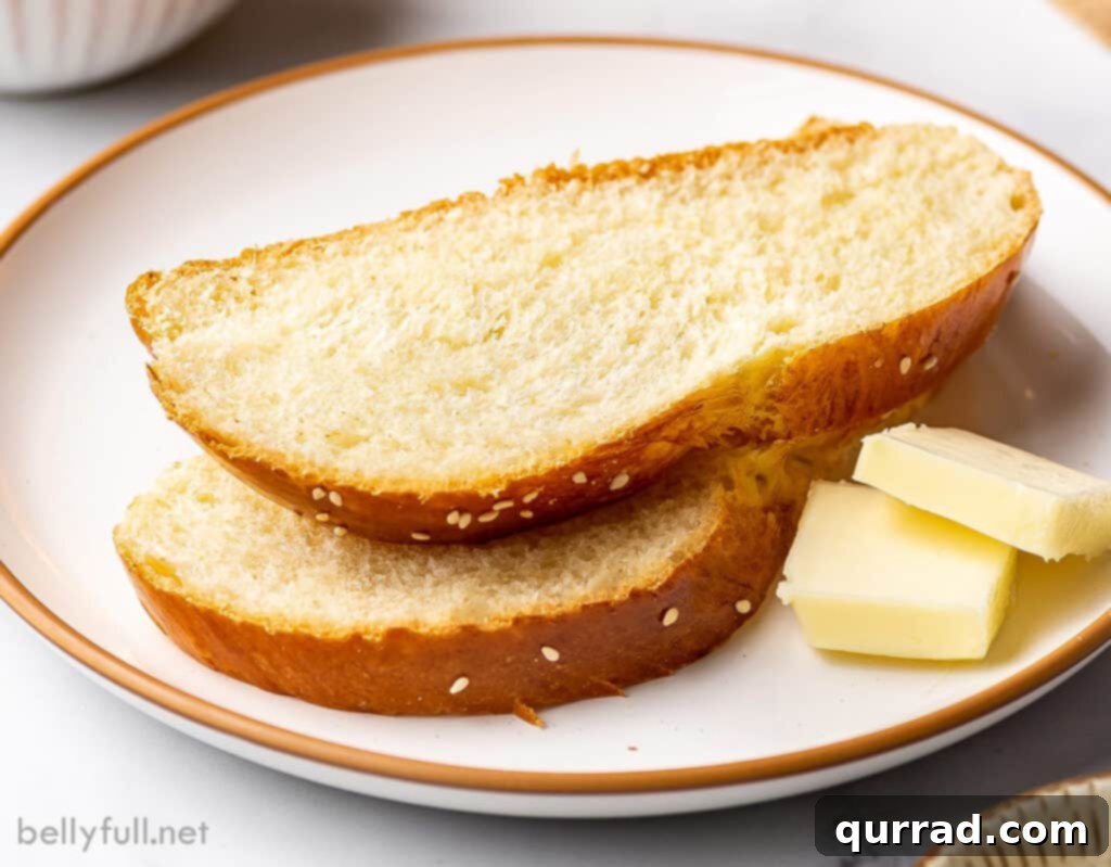 Golden Braided Challah 6 2 slices of bread stacked on plate with pats of butter