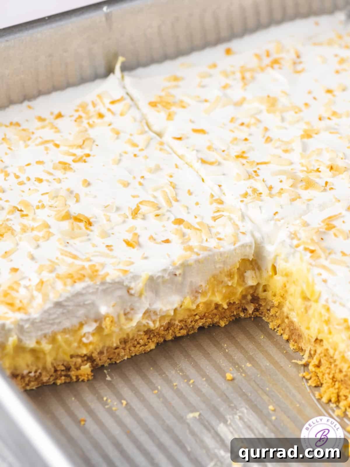 Pineapple Paradise Lush 2 A perfectly sliced square of No-Bake Pineapple Lush Dessert in a baking pan, showing off its beautiful layers.