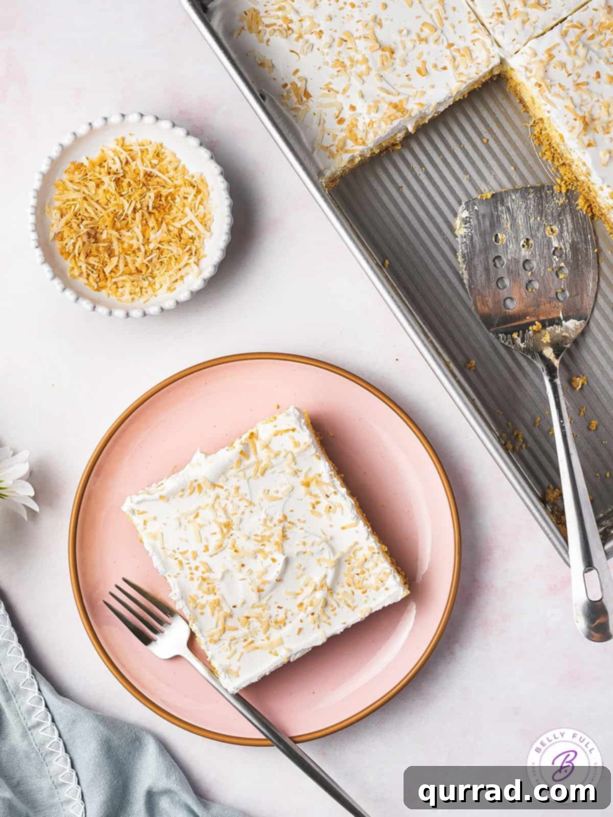 Pineapple Paradise Lush 4 A delectable square slice of pineapple lush dessert on a white plate, with a fork poised to take a bite.
