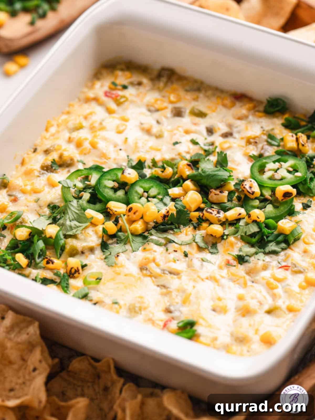 Golden Corn Goodness 2 Creamy corn dip in a casserole dish garnished with sliced jalapenos, ready to serve.