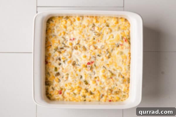 Hot creamy corn dip in a casserole dish, fresh out of the oven, bubbly and golden.