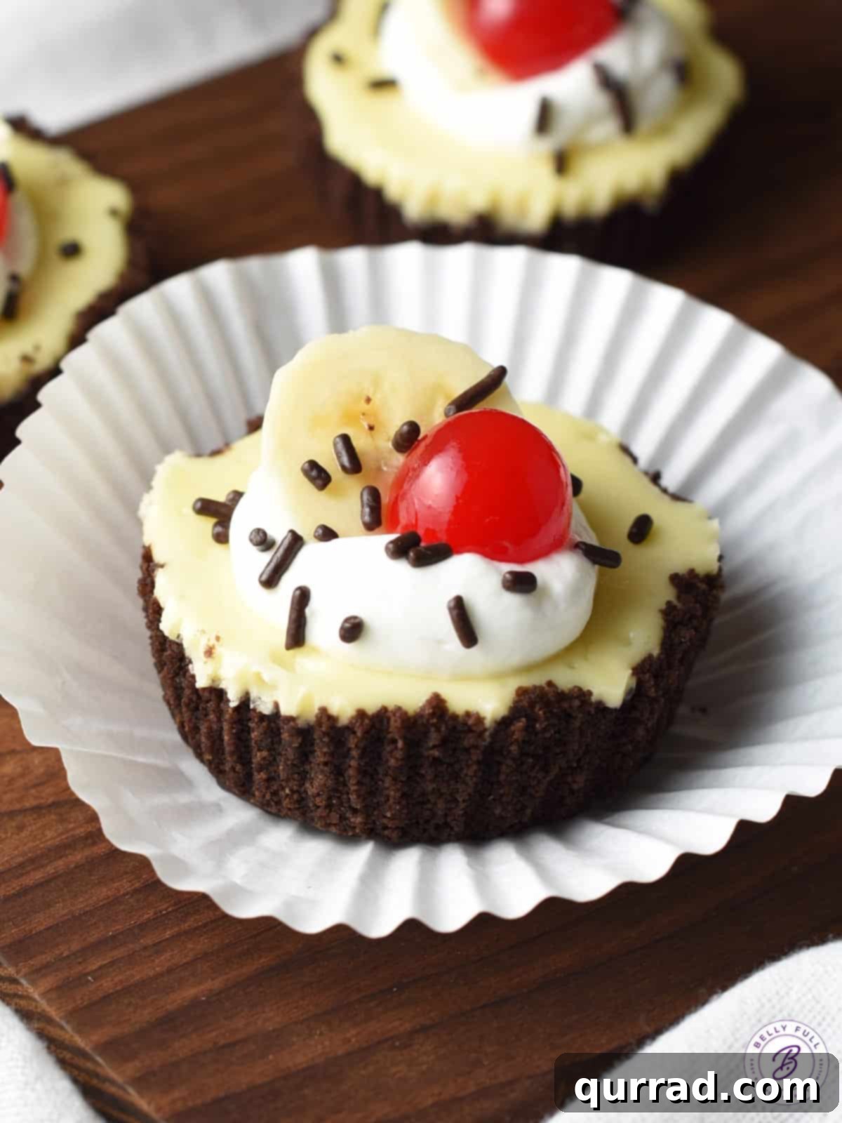 Banana Split Cheesecake Bites 4 banana split mini cheesecake on top of paper liner