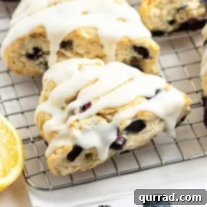 close up glazed lemon blueberry scone on cooling rack