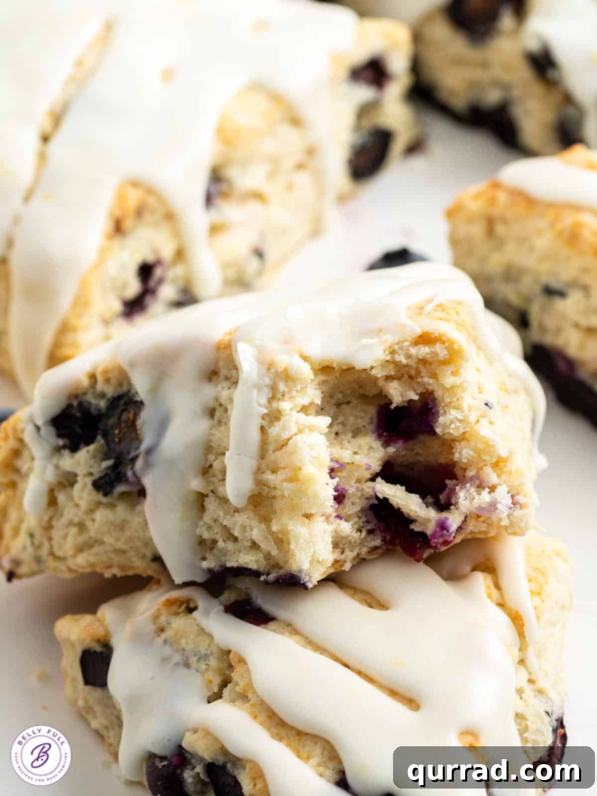 Zesty Lemon Blueberry Scones 5 close up glazed lemon blueberry scone with bite taken