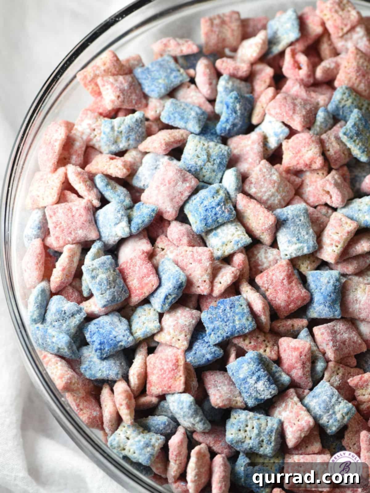Star-Spangled Snack Mix 2 A vibrant overhead shot of a bowl brimming with red, white, and blue muddy buddies, perfect for patriotic celebrations.